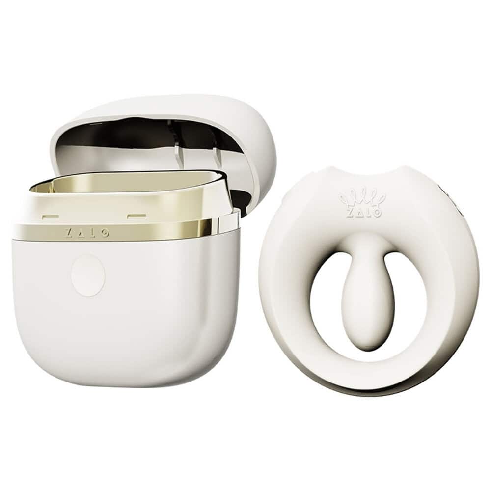 Cockring connecté APIS présenté avec son étui de recharge, câble USB et carte de garantie, disposés sur fond clair dans une mise en scène minimaliste et élégante.
