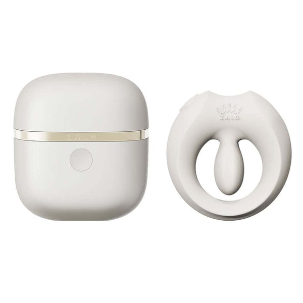 Cockring connecté APIS présenté avec son étui de recharge, câble USB et carte de garantie, disposés sur fond clair dans une mise en scène minimaliste et élégante.