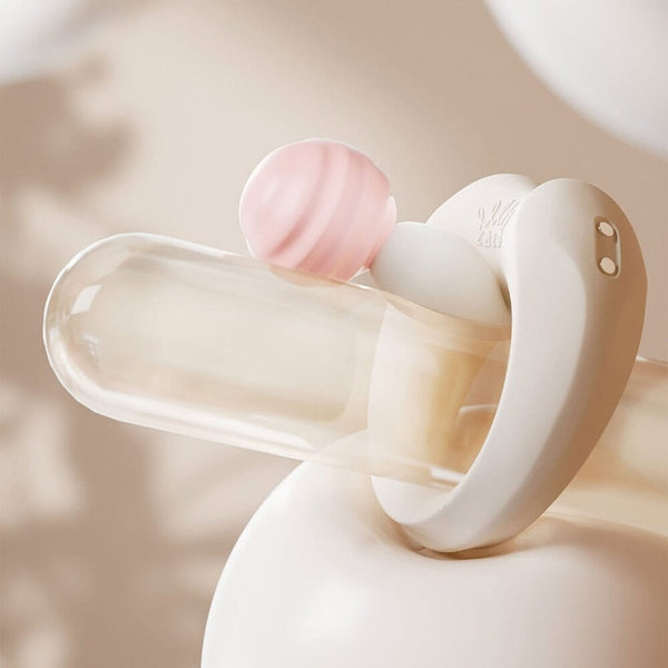 Cockring connecté APIS présenté avec son étui de recharge, câble USB et carte de garantie, disposés sur fond clair dans une mise en scène minimaliste et élégante.