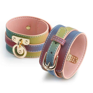Menottes de chevilles en cuir multicolore Rainbow avec doublure rose, coutures contrastées et boucles dorées, présentées sur fond blanc dans une esthétique élégante.
