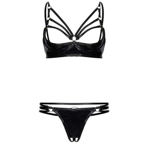 Modèle portant un ensemble deux pièces en latex noir, avec soutien-gorge ouvert à lanières graphiques et bas échancré, mettant en valeur la silhouette.