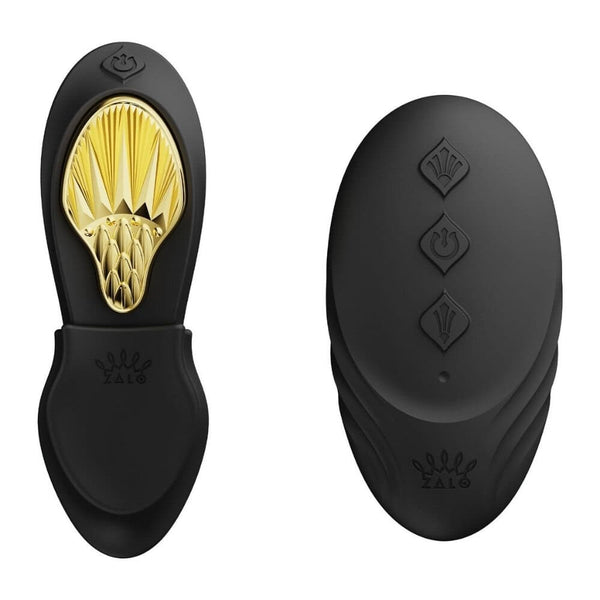 Vibromasseur portable de couleur noire avec détails dorés, design ergonomique et commandes intégrées, présenté sur fond blanc, sélection Brigade Mondaine Paris.