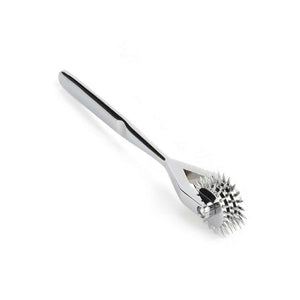 Roulette de Wartenberg en acier inoxydable brillant avec roulettes dentelées, design médical revisité, présentée par Brigade Mondaine Paris sur fond clair.