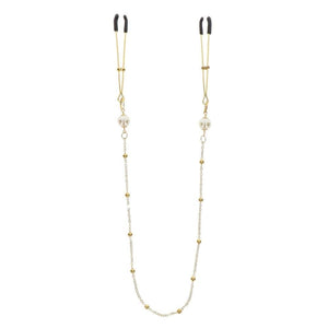 Pinces à tétons dorées avec chaîne fine et perles, portées sur le buste, accessoire sensuel proposé par Brigade Mondaine Paris.