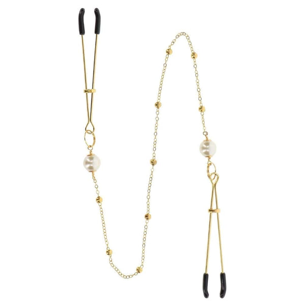 Pinces à tétons dorées avec chaîne fine et perles, portées sur le buste, accessoire sensuel proposé par Brigade Mondaine Paris.