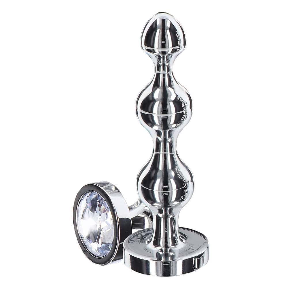 Plug anal en métal poli avec cristal facetté transparent, base évasée et finition brillante, présenté par Brigade Mondaine Paris.