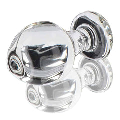 Plug anal en verre transparent poli à finition brillante, forme sphérique avec base évasée, présenté sur fond blanc, sélection Brigade Mondaine Paris.