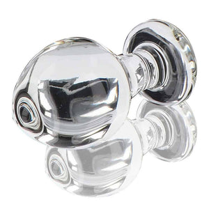 Plug anal en verre transparent poli à finition brillante, forme sphérique avec base évasée, présenté sur fond blanc, sélection Brigade Mondaine Paris.