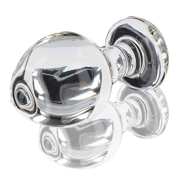 Plug anal en verre transparent poli à finition brillante, forme sphérique avec base évasée, présenté sur fond blanc, sélection Brigade Mondaine Paris.