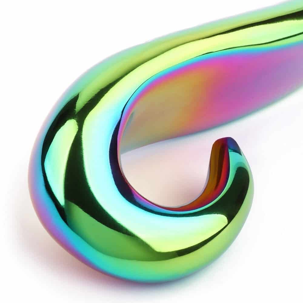 Devil's Dildo en acier inoxydable finition irisée, forme courbée et surface lisse, présenté par Brigade Mondaine Paris sur fond clair.