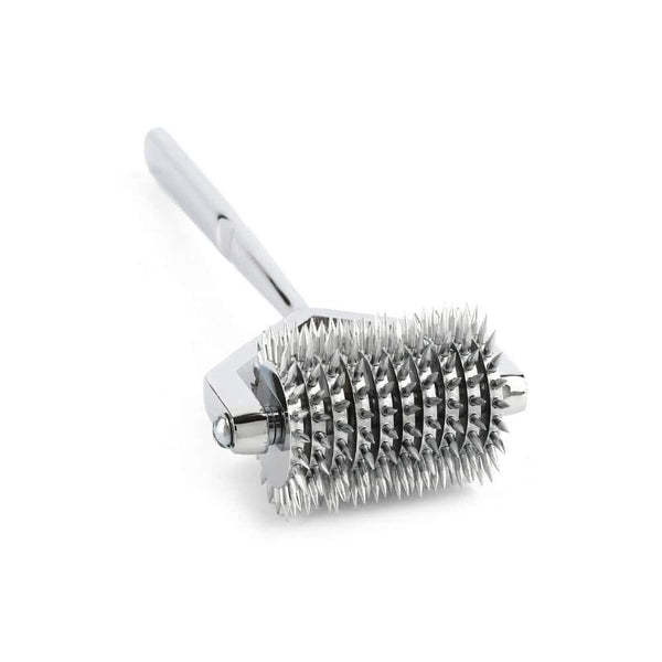 Roulette de Wartenberg en acier inoxydable brillant avec roulettes dentelées, design médical revisité, présentée par Brigade Mondaine Paris sur fond clair.