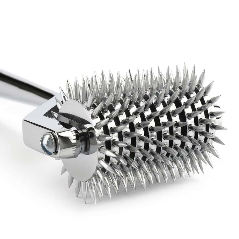 Roulette de Wartenberg en acier inoxydable brillant avec roulettes dentelées, design médical revisité, présentée par Brigade Mondaine Paris sur fond clair.