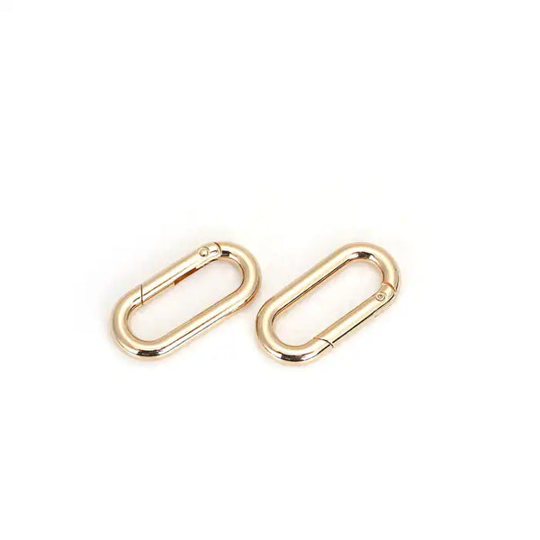 Barre d’écartement en cuir noir embossé peau d’autruche avec clips à dégagement rapide et finitions dorées. Accessoire BDSM de contrôle élégant.
