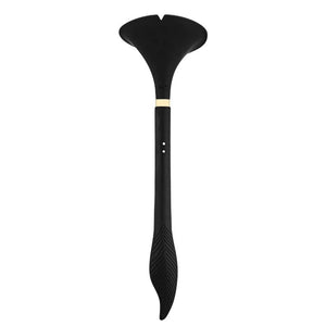 Stimulateur intime noir à la forme ergonomique, présenté avec un pochon de rangement noir siglé, photographié sur fond blanc dans une mise en scène épurée et raffinée.