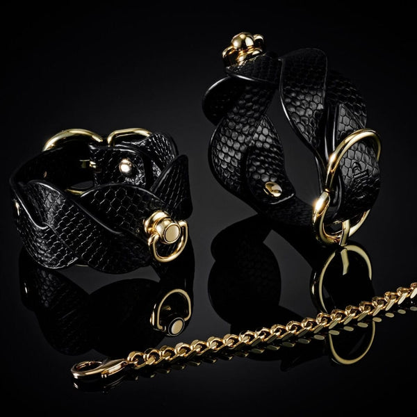 Modèle portant un collier BDSM noir texturé avec chaîne dorée et dragonne assortie, accessoire de contrainte proposé par Brigade Mondaine Paris.