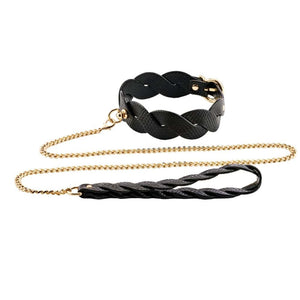 Modèle portant un collier BDSM noir texturé avec chaîne dorée et dragonne assortie, accessoire de contrainte proposé par Brigade Mondaine Paris.