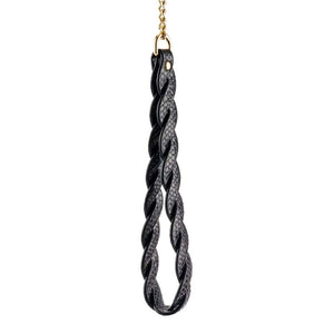 Modèle portant un collier BDSM noir texturé avec chaîne dorée et dragonne assortie, accessoire de contrainte proposé par Brigade Mondaine Paris.