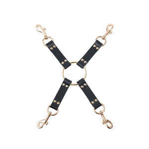 Hogtie BDSM en cuir noir composé de quatre sangles reliées par un anneau central doré, équipé de mousquetons métalliques pour la fixation.