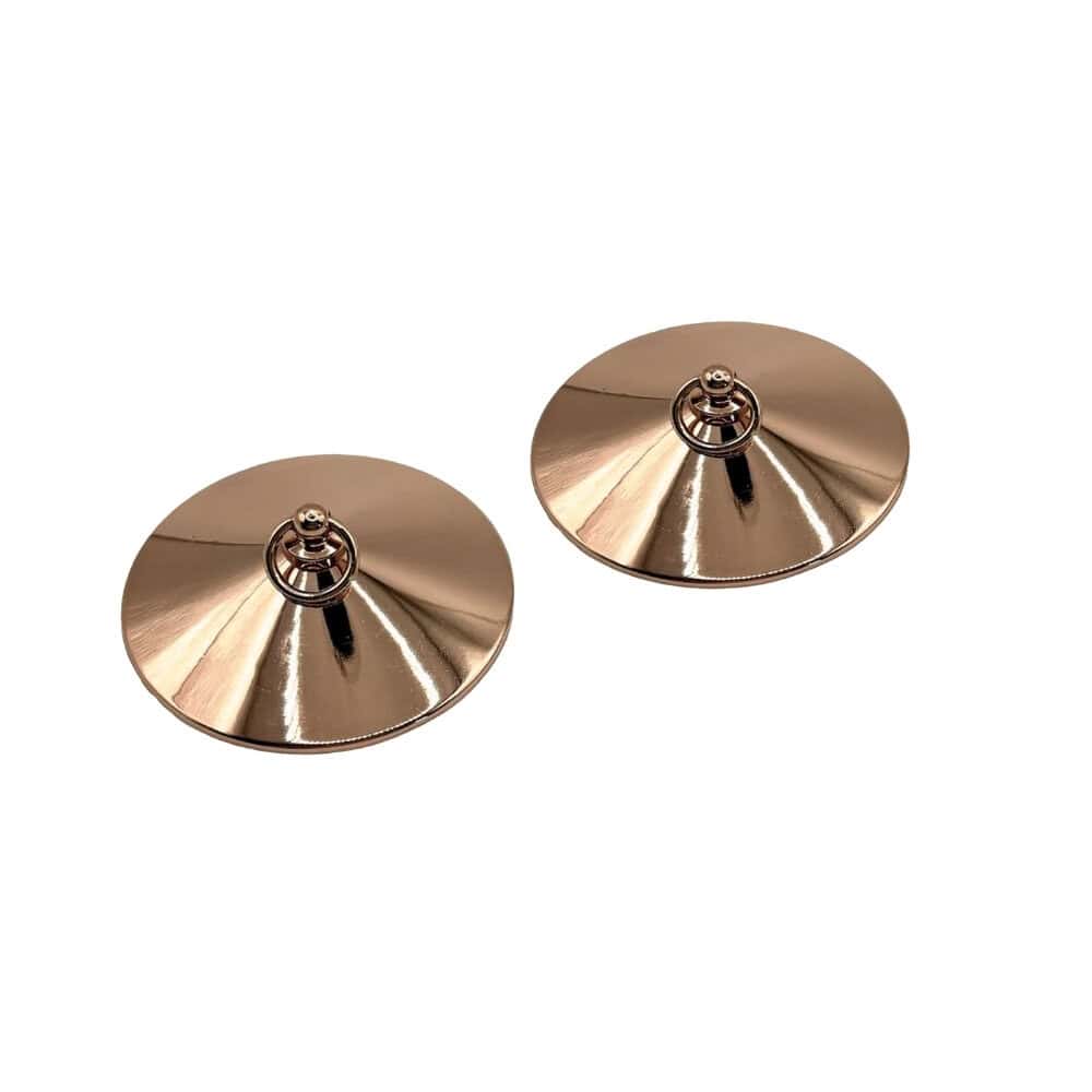 Paire de cache-tétons en métal doré à surface lisse et circulaire, chacun doté d’un petit anneau central, présentés sur fond blanc dans une esthétique minimaliste et élégante.