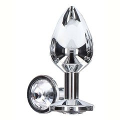 Plug anal en métal argenté poli effet miroir, à la forme lisse et effilée avec base plate assurant stabilité, présenté sur fond blanc dans une esthétique épurée.