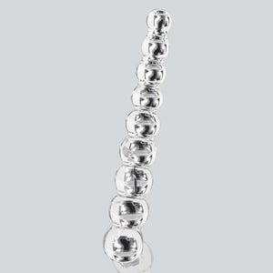 Dildo en verre transparent composé de formes sphériques alignées, présenté verticalement sur fond blanc, avec une finition lisse et brillante.