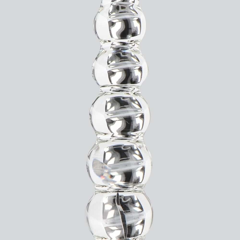 Dildo en verre transparent composé de formes sphériques alignées, présenté verticalement sur fond blanc, avec une finition lisse et brillante.