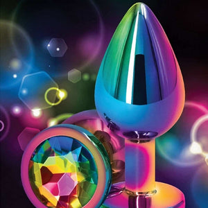 Plug anal en cristal multicolore avec base décorative en forme de cœur facetté, présenté sur fond sombre avec effets lumineux et reflets irisés.