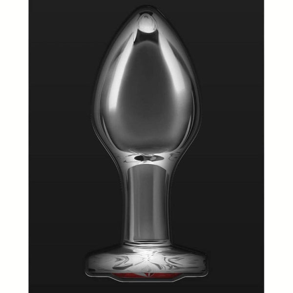 Plug anal en cristal transparent posé sur fond noir, avec une base décorative en forme de cœur rouge facetté, à l’esthétique élégante et raffinée.