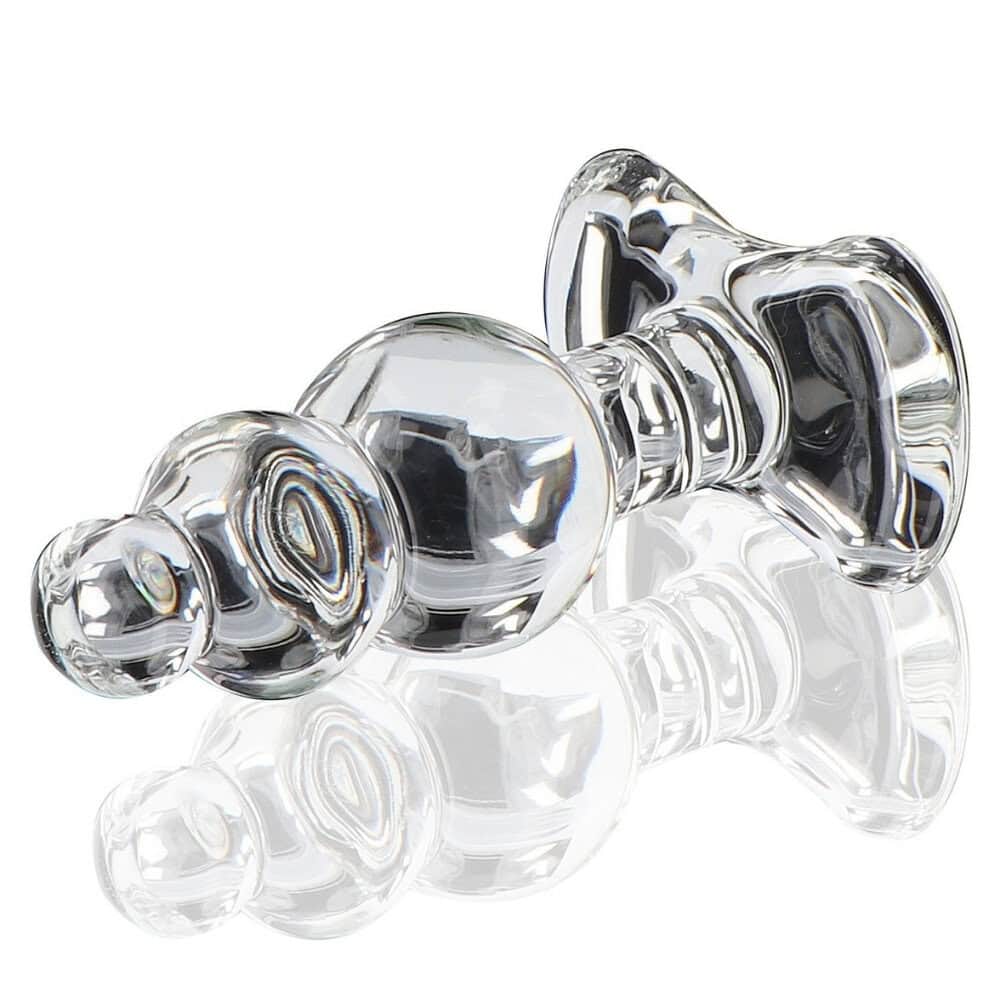 Plug anal en verre transparent à forme facettée avec base évasée, présenté sur fond clair, finition brillante, sélection Brigade Mondaine Paris.
