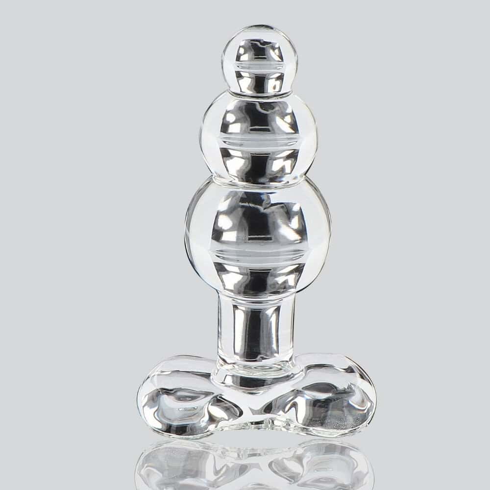 Plug anal en verre transparent à forme facettée avec base évasée, présenté sur fond clair, finition brillante, sélection Brigade Mondaine Paris.