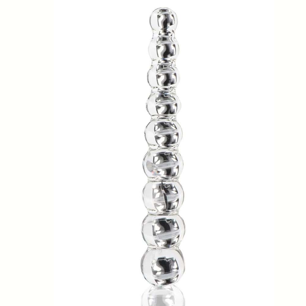 Dildo en verre transparent composé de formes sphériques alignées, présenté verticalement sur fond blanc, avec une finition lisse et brillante.