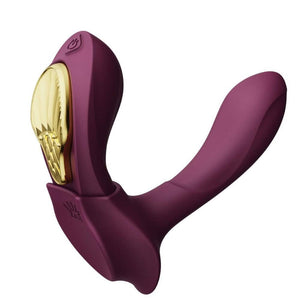 Vibromasseur portable de couleur prune avec détails dorés, design ergonomique et commandes intégrées, présenté sur fond blanc, sélection Brigade Mondaine Paris.
