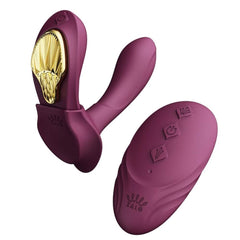 Vibromasseur portable de couleur prune avec détails dorés, design ergonomique et commandes intégrées, présenté sur fond blanc, sélection Brigade Mondaine Paris.