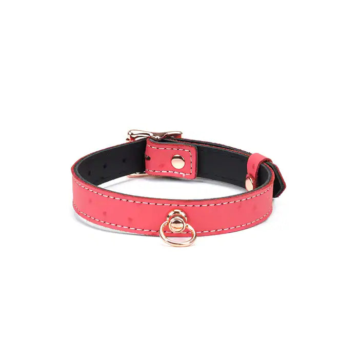 Choker O en cuir rose cerisier, embossé peau d’autruche, avec anneau central. Finition métal or rose, ajustable avec boucle dorée. Accessoire fétichiste chic pour marquer l’appartenance.