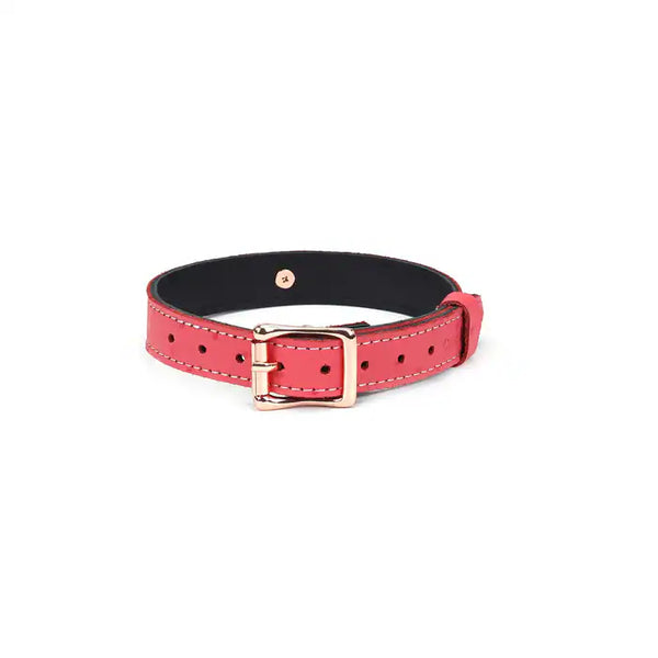 Choker O en cuir rose cerisier, embossé peau d’autruche, finition métal or rose. Ajustable avec boucle dorée, anneau central pour accessoires. Accessoire fétichiste chic et sensuel.
