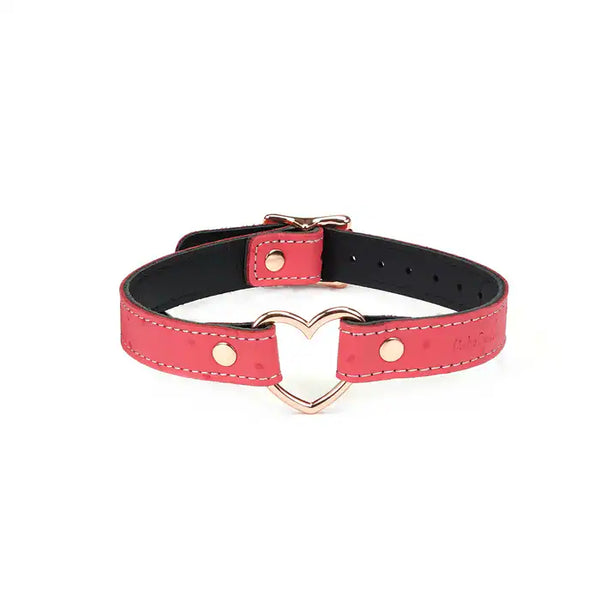 Choker Cœur en cuir rose cerisier embossé peau d’autruche avec cœur central en métal or rose. Ajustable grâce à boucle métallique. Accessoire fétichiste pour jeux de pouvoir.
