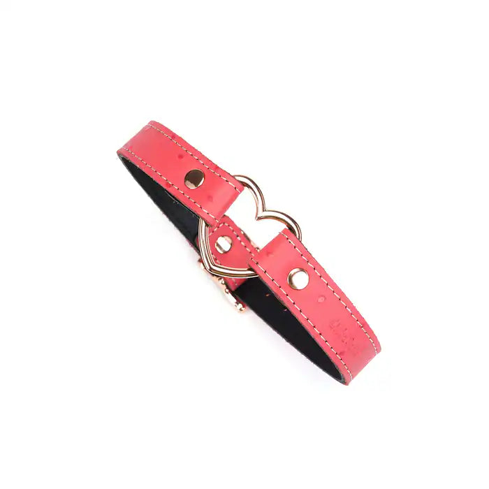 Choker Cœur en cuir rose embossé peau d’autruche avec cœur central en métal or rose. Boucle métallique robuste. Accessoire fétichiste séduisant et affirmatif. Ajustable pour un confort parfait.