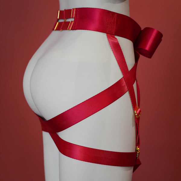 Harnais bas du corps UPKO en sangles croisées noires avec nœud papillon, enlaçant taille et fesses – accessoire bondage élégant et graphique.