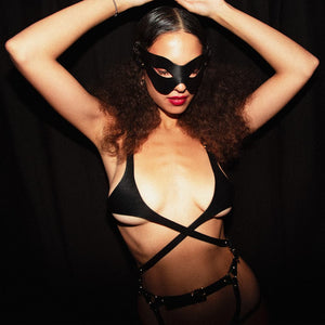 Soutien gorge en cuir noir de la marque Elif Domanic. Ce soutien gorge s’apparente presque à la forme d’un harnais grâce à ses tours de taille en cuir qui s’attache au niveau du nombril par le biais d’une fine boucle argenté. La poitrine est cachée par une pièce recouvrant une petite partie des seins. Cet ensemble est relié aux bretelles par deux anneaux argentés avec à l’arrière une lanière munie d’une boucle et de quelques clous. A l’intérieur de la bretelle de droite se trouve une plaquette argentée embo