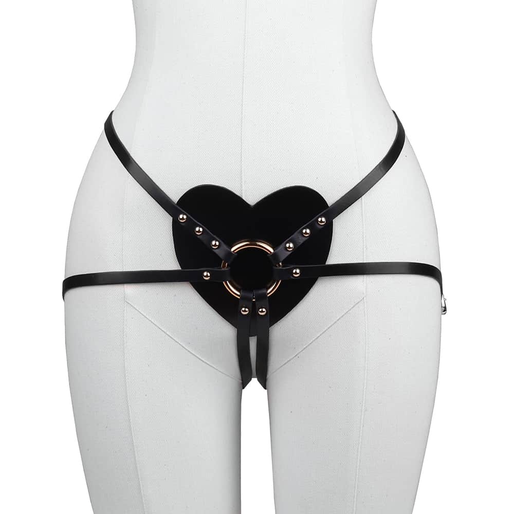 Culotte Harnais en cuir noir de la marque Elif Domanic. Ce harnais comporte un coeur élégant en cuir placé au niveau du bas ventre avec en son centre un anneau en laiton doré qui rassemble les lanières placés sur le bas du dos et pour les tours de cuisses. De fines boucles ainsi que quelques clous de couleur or sont placés de part et d’autre du produit.