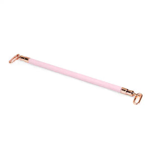 Barre d'écartement en cuir rose de la collection Fairy, en cuir d'agneau et bois d'eucalyptus, avec anneaux métalliques or rose. Un accessoire BDSM élégant pour maintenir la soumission avec douceur et fermeté.