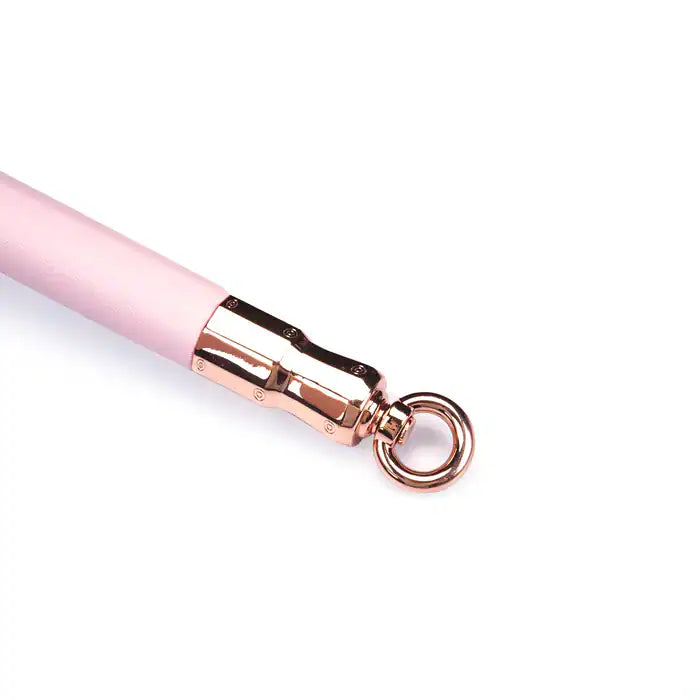 Barre d'écartement en cuir rose de la collection Fairy, en cuir d'agneau et bois d'eucalyptus, avec anneaux métalliques or rose. Un accessoire BDSM élégant pour maintenir la soumission avec douceur et fermeté.