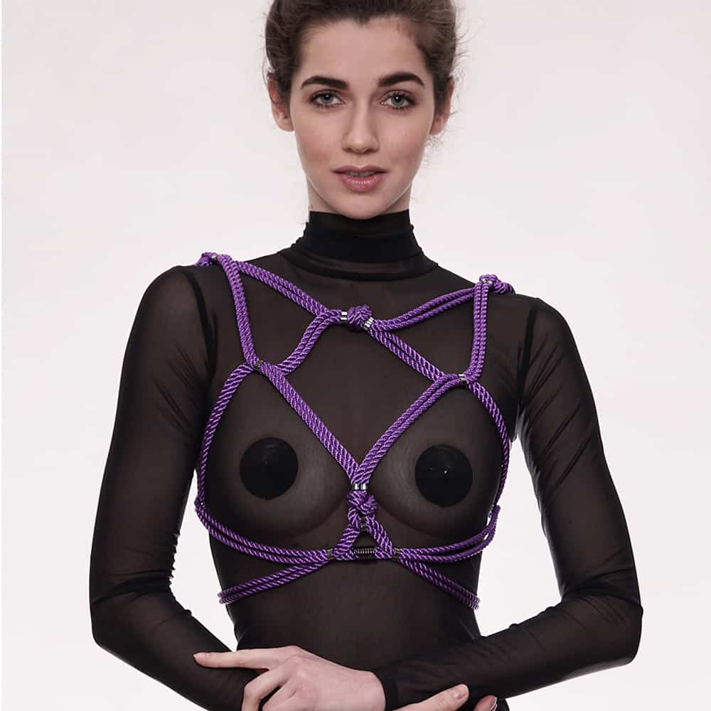 A woman wearing a black bodysuit with a gold chain