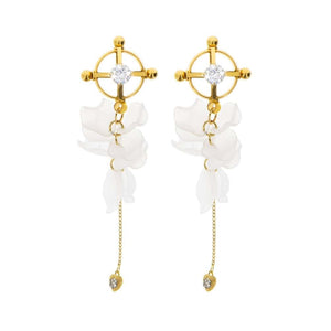 Modèle portant des pinces à tétons florales dorées avec pampilles translucides et chaîne fine, accessoire proposé par Brigade Mondaine Paris.