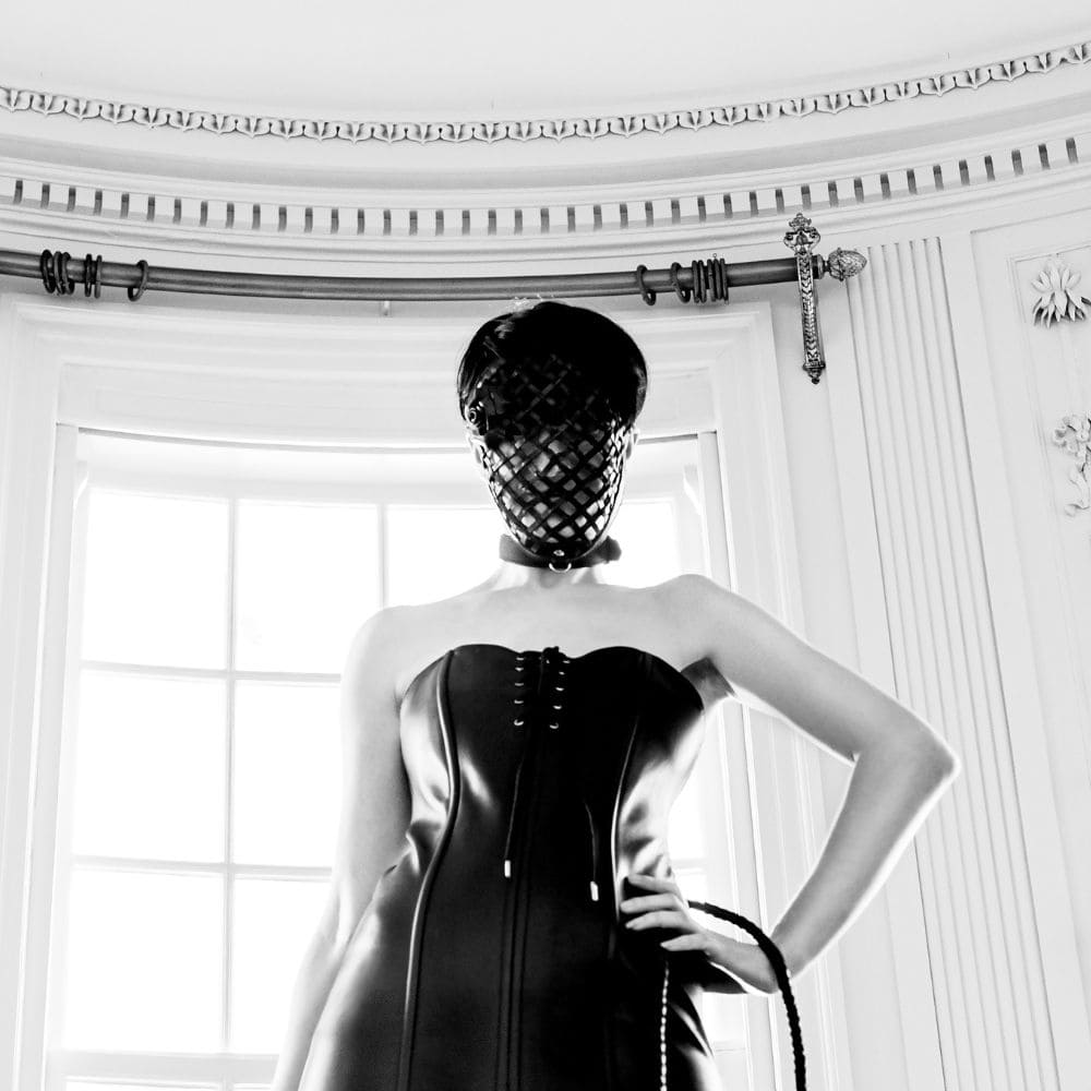 Photo Femme Robe Cuir style Corset Detail Lacet en Haut et Bas avec Masque Bondage Cuir Noir et Fouet Serpent en Cuir noir Brillant