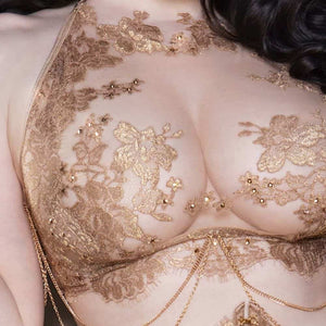 L’accessoire chaîne AIMÉE rehausse votre lingerie avec une touche précieuse et raffinée. Ses chaînes dorées délicates, dotées de clips sophistiqués, s’attachent facilement au soutien-gorge long AIMÉE pour un effet bijou subtil. Conçu pour sublimer votre silhouette, il allie glamour et élégance intemporelle. Entièrement fabriqué à la main, il incarne l’art du détail et du luxe.