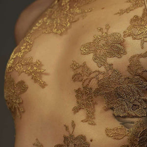 Le body licou AMMALIE sublime la silhouette avec son effet seconde peau et son éclat doré subtil. Confectionné à la main en maille illusion ultra-transparente, il épouse le corps avec finesse. Son appliqué en dentelle Leavers française en or rosé, découpé et cousu à la main, ajoute une touche précieuse. Les bretelles dorées réglables et les accessoires plaqués or 24 carats assurent un ajustement parfait. Pour un confort optimal, l’intérieur est doublé en coton de bambou biologique.