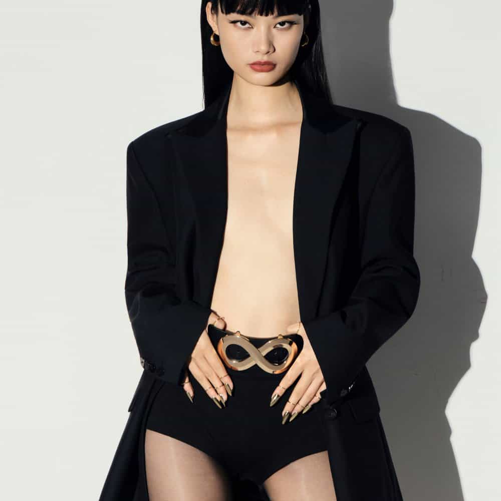 Ceinture AELLIA IINFYNII noire avec fermoir métallique en forme d’infini portée à la taille, accessoire graphique et contemporain proposé par Brigade Mondaine Paris