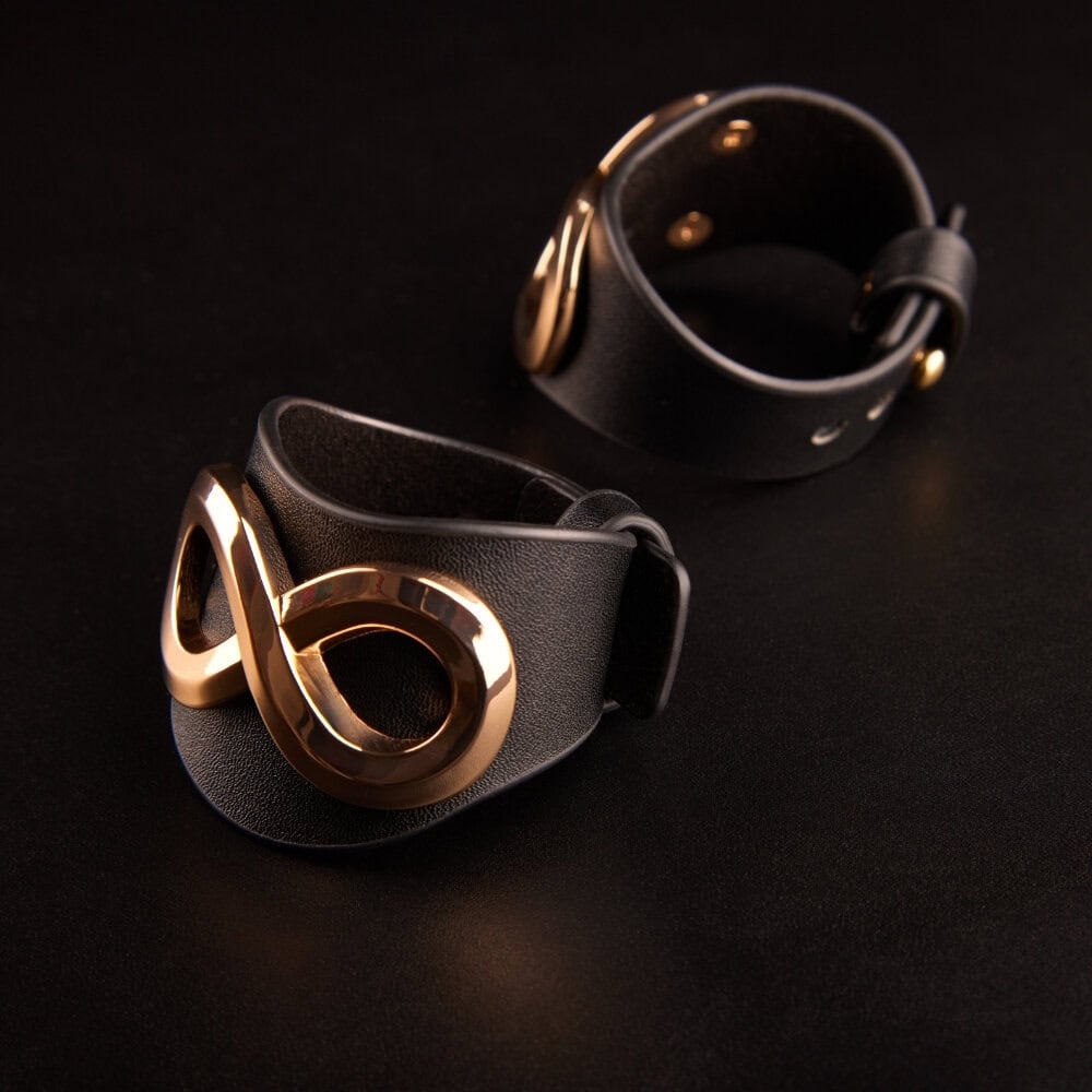 Bracelets SASKIA IINFYNII en cuir noir avec anneau métallique doré, détail de bracelet ajustable, accessoire de corps sélection Brigade Mondaine Paris
