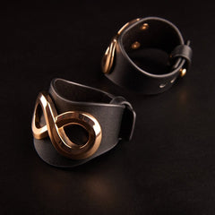 Bracelets SASKIA IINFYNII en cuir noir avec anneau métallique doré, détail de bracelet ajustable, accessoire de corps sélection Brigade Mondaine Paris